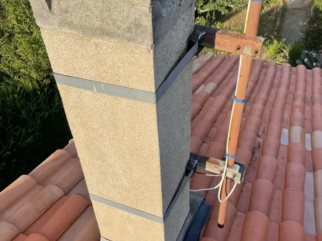 Reconstruction d'une souche de cheminée en cours, enduit fraîchement appliqué sur toiture en tuiles canal — Artisan JP